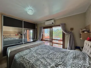 Quarto com cama e janela de madeira.