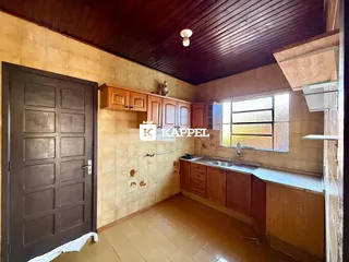 Cozinha com armários de madeira e piso de madeira.