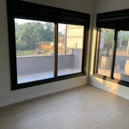 Vista interna de um cômodo com grande janela.