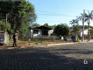 Vista da fachada de uma propriedade com cerca e vegetação em Lajeado.