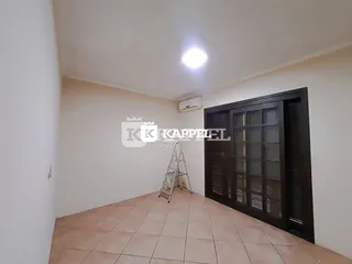 Vista interna de um ambiente com piso de cerâmica e um armário escuro na parede.