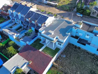 Vista aérea de um conjunto residencial com casas de telhado de telhas escuras em Lajeado.