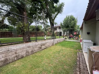 Vista externa de um quintal com cerca e muro de tijolos em Lajeado.