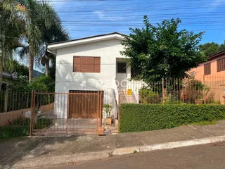 Fachada de uma casa em Lajeado, Brasil com cerca e portão de ferro.
