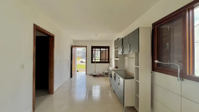 Foto de um corredor com piso de cerâmica e uma cozinha moderna em um imóvel.
