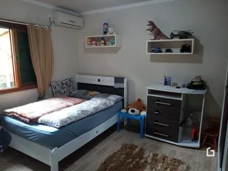 Quarto com cama e estantes de parede em um imóvel no Brasil.