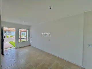 Interior de uma sala com piso de cerâmica e porta de acesso ao exterior.