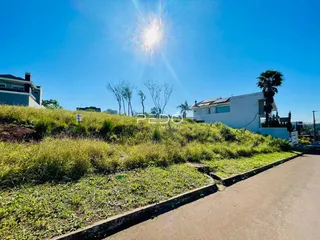 Vista externa de uma residência com terreno gramado e inclinado em Lajeado.