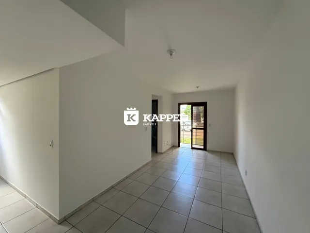 Corredor com piso de cerâmica e porta de vidro que dá acesso à área externa.