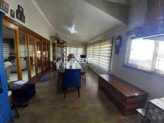 Interior de uma sala de jantar com piso de madeira e portas de madeira.