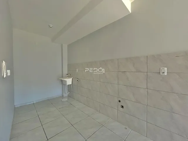 Vista interna de um ambiente com piso e parede revestidos de cerâmica.