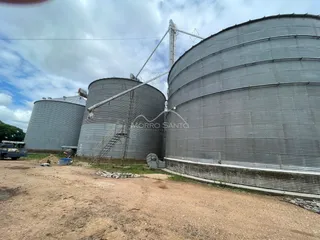 Foto de grandes tanques industriais metálicos em uma área externa de armazenamento.