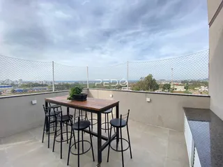 Varanda com mesa e bancos com vista para a paisagem.