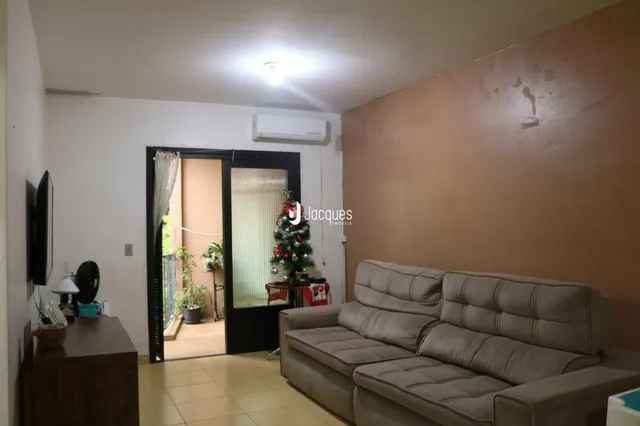 Sala de estar com sofá e porta de entrada em uma residência.