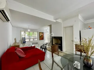 Sala de estar com sofá vermelho e lareira em um imóvel em Lajeado.