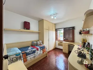 Quarto com cama e armário em madeira no imóvel.