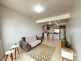 Sala de estar com sofá e tapete em um apartamento no Brasil.