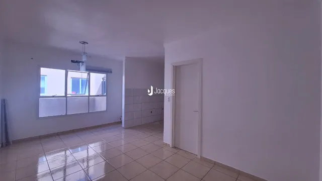 Ambiente interno de uma sala com piso de cerâmica e janela.