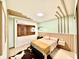 Quarto com cama de casal e armário de madeira na parede.