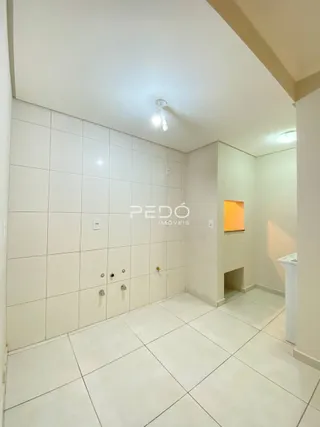 Interior de um ambiente com piso e paredes brancas revestidas de cerâmica.