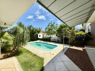 Foto de uma piscina externa com deck e jardim em uma propriedade.