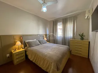Quarto com cama de casal e móveis de madeira.