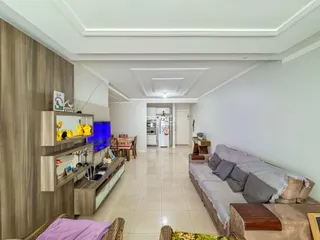 Interior de uma sala de estar com piso de cerâmica e painel de madeira.