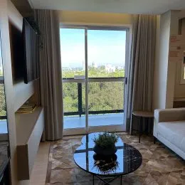 Sala de estar com grandes janelas que oferecem uma vista panorâmica da paisagem.