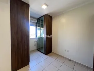 Interior de um corredor com portas de madeira e piso de cerâmica.