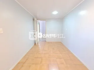 Vista interna de um corredor com piso de cerâmica clara.