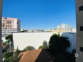 Fachada de um edifício branco em Lajeado, Brasil, sob céu azul.