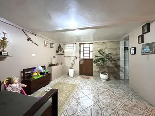 Foto interna de uma sala com piso de cerâmica e móveis de madeira.