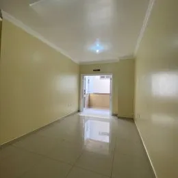 Hall de corredor com paredes claras e piso liso.