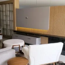 Foto de um ambiente interno com móveis brancos e piso escuro.