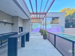 Vista da área externa com piscina e deck da residência.