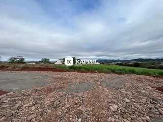 Vista externa de uma propriedade com campo gramado e sinalização.