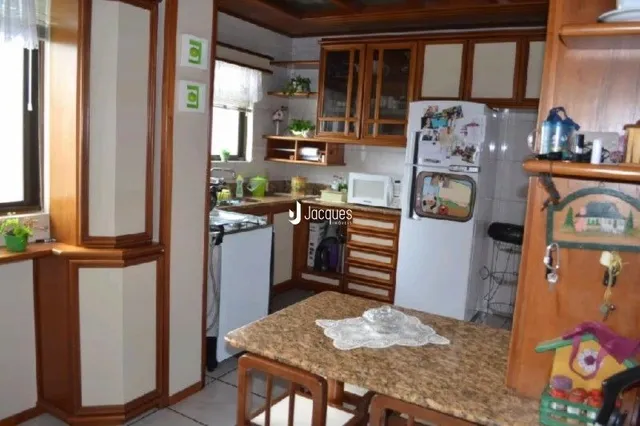 Foto de uma cozinha com armários de madeira e geladeira.