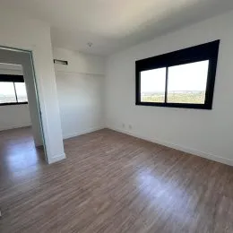 Foto de um cômodo interno com piso de madeira e janela.