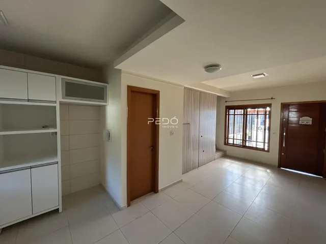 Interior de uma sala com piso de cerâmica e armários brancos.
