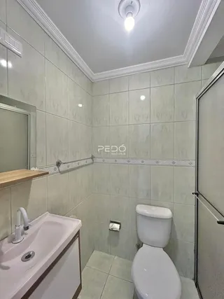 Foto de um banheiro com revestimento cerâmico claro.