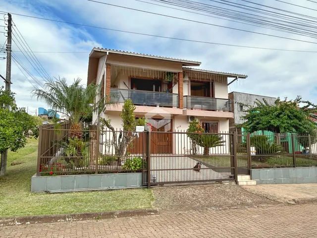 Fachada de uma residência em Lajeado, Brasil, com cerca e jardim.