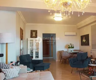 Sala de estar com teto alto e lustre de cristal em um imóvel em Lajeado.