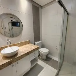 Foto de um banheiro com pia e bancada de granito.