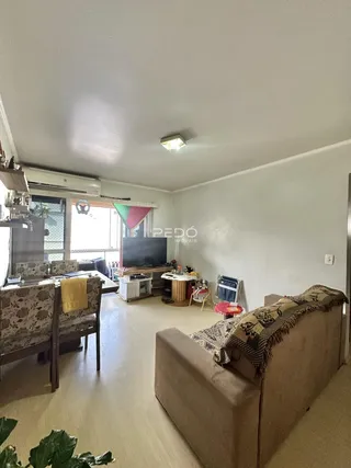 Sala de estar e jantar com piso de madeira clara e móveis de estofado.