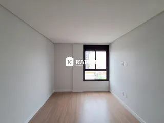 Esta é uma sala de estar com piso de madeira clara e uma grande janela.