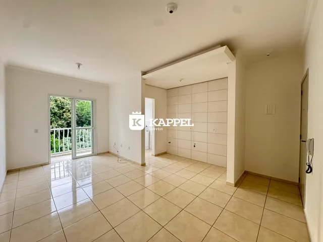 Uma sala ampla com piso de cerâmica e porta de vidro que dá acesso ao exterior.
