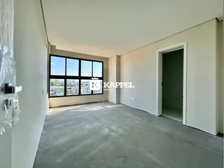 Sala ampla com grande janela de vista para a cidade.