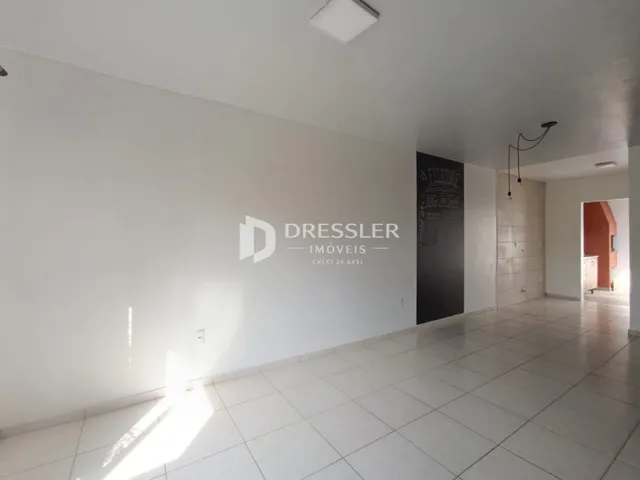 Hall de entrada com piso de cerâmica clara e paredes brancas.