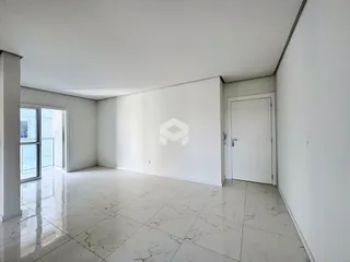 Ambiente interno de uma sala ampla com piso de porcelanato claro.
