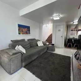 Sala de estar com sofá e paredes brancas.